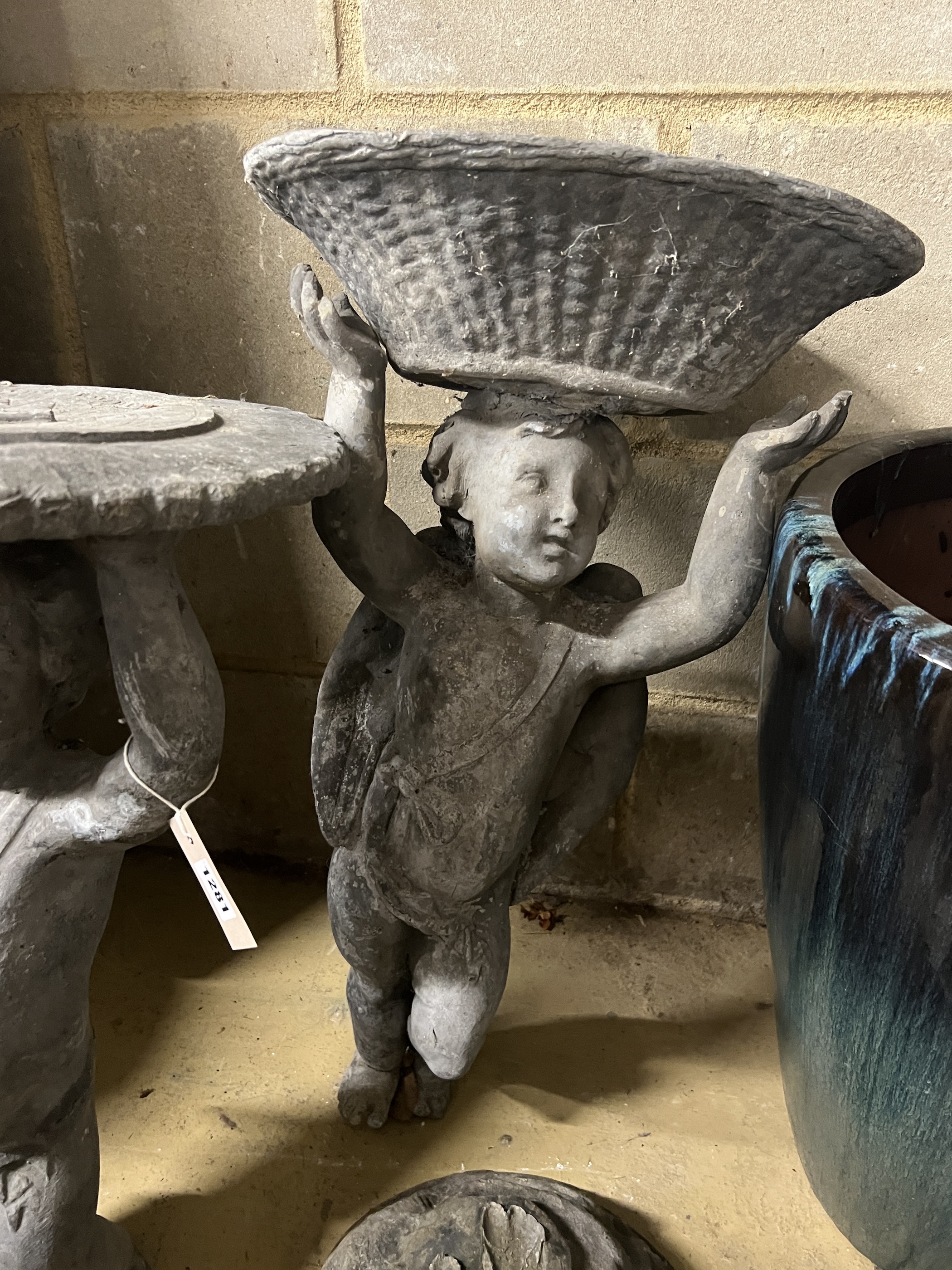 Two Victorian lead garden putto figures, one as a sundial, the other a birdbath, in need of restoration, larger height 69cm